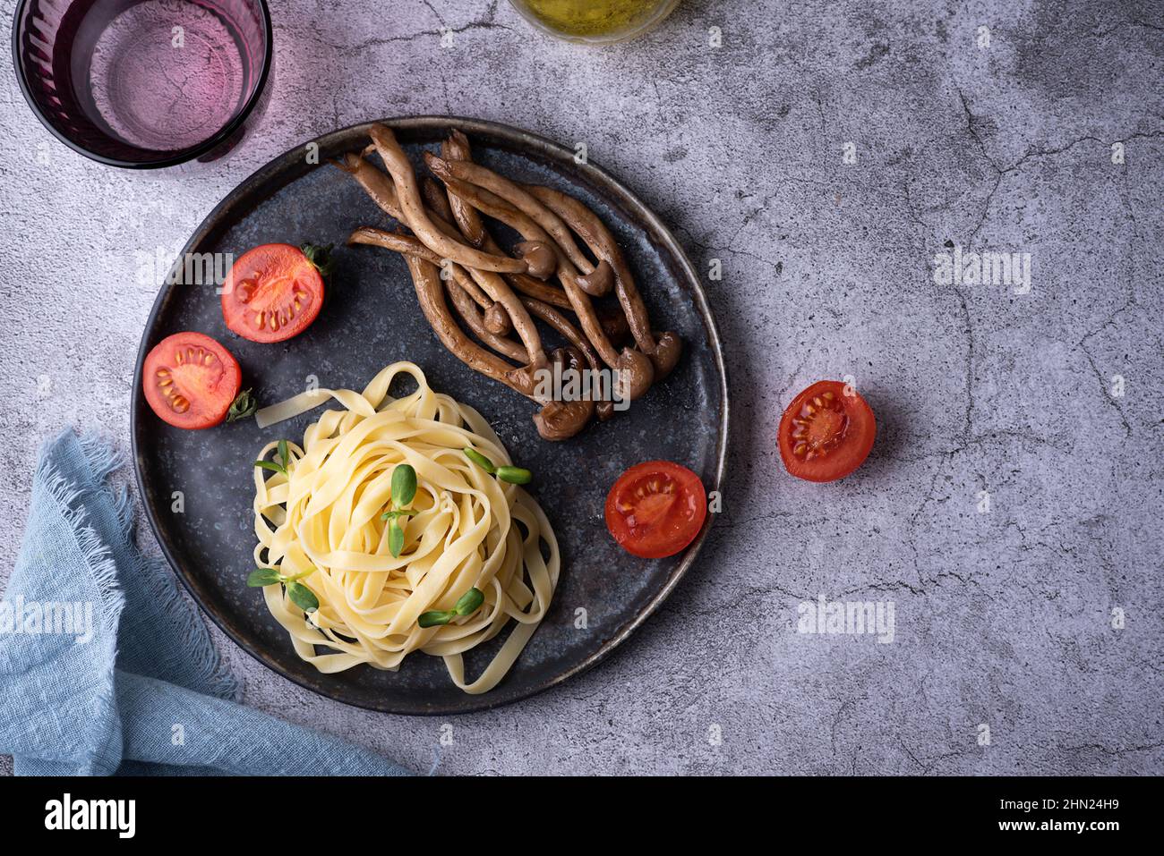 Gekochte Shimeji und Nudeln, Pasta mit gebratenen Pilzen auf dem Teller auf grauem Hintergrund. Stockfoto