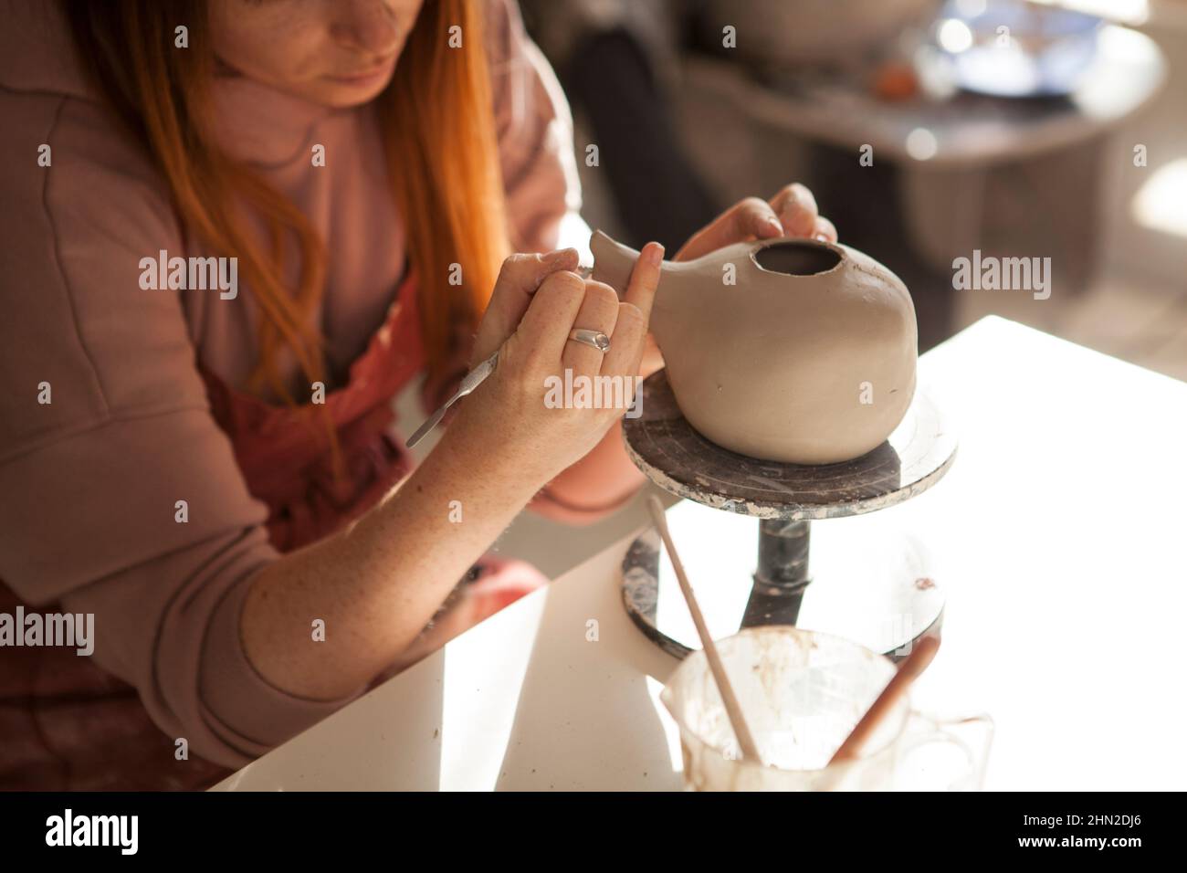 Kurzer Schuss eines Keramikers, der handgemachte Teekannen aus Ton schmückt Stockfoto