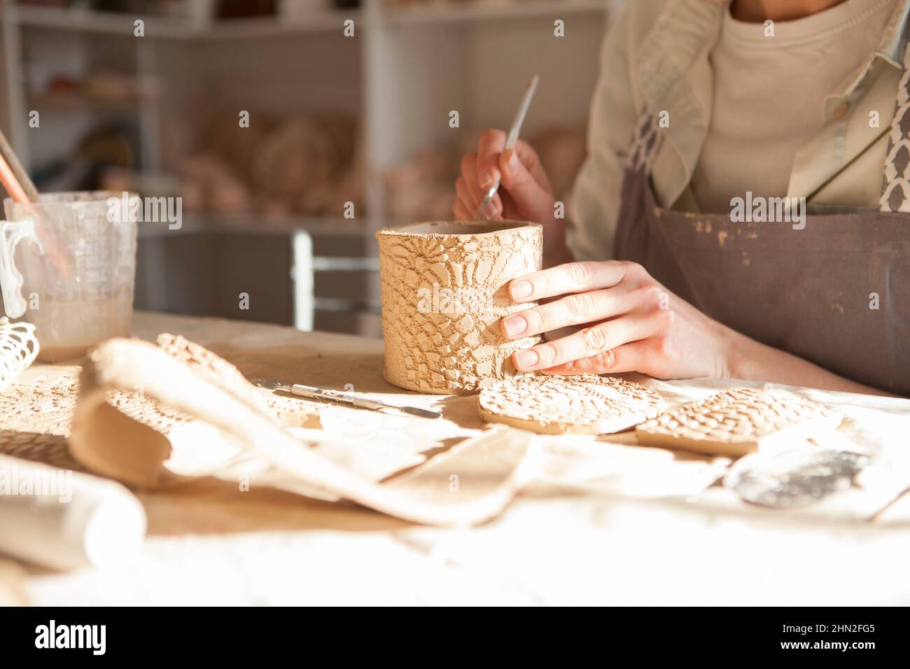 Beschnittene Nahaufnahme von Keramikbecher unkenntlich Frau macht in der Art Class, Copy Space Stockfoto