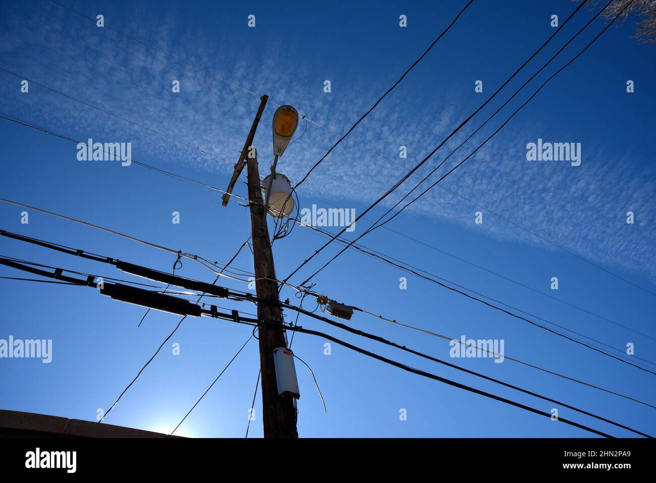 Elektrische Stromleitungen und ein Telefonmast durcheinander den Himmel in Santa Fe, New Mexico. Stockfoto