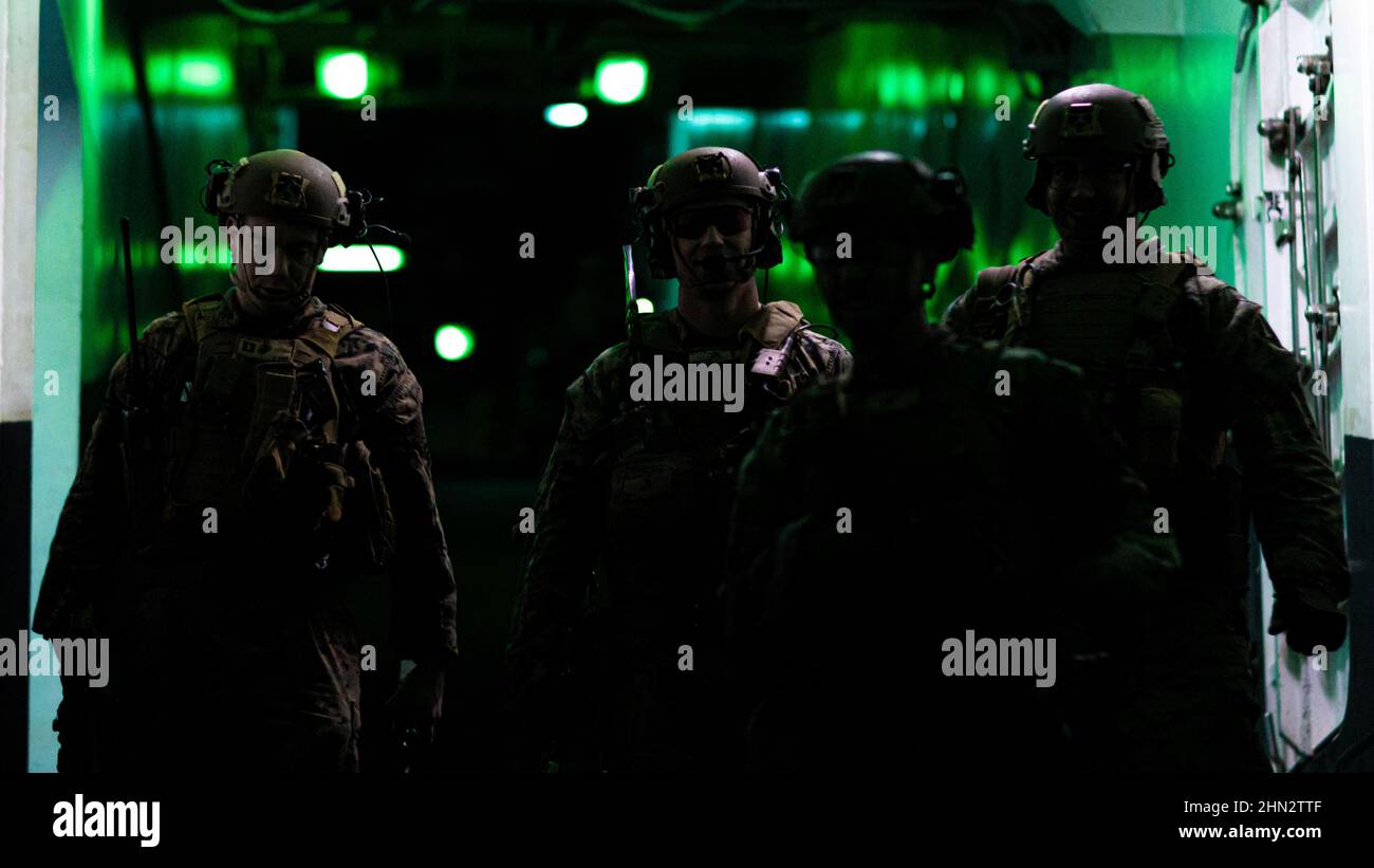 U.S. Marines mit Bataillon Landing Team 1/5, 31st Marine Expeditionary Unit (MEU), nach einer taktischen Bergung von Flugzeugen und Personal (TRAP), philippinische See, 9. Februar 2022, gehen Sie die Fluglinienrampe an Bord des amphibischen Angriffsschiffes USS America (LHA 6) entlang. Neben der Rückgewinnung von Personal und Flugzeugen sind DIE TRAP-Teams auch damit beauftragt, sensibles Material zu zerstören, wenn es als notwendig erachtet wird, um dem Feind den Zugang zu verweigern. Die 31st MEU ist an Bord von Schiffen der America Expeditionary Strike Group im Einsatzgebiet der 7th Flotten tätig, um die Interoperabilität mit Verbündeten und Partnern und s zu verbessern Stockfoto