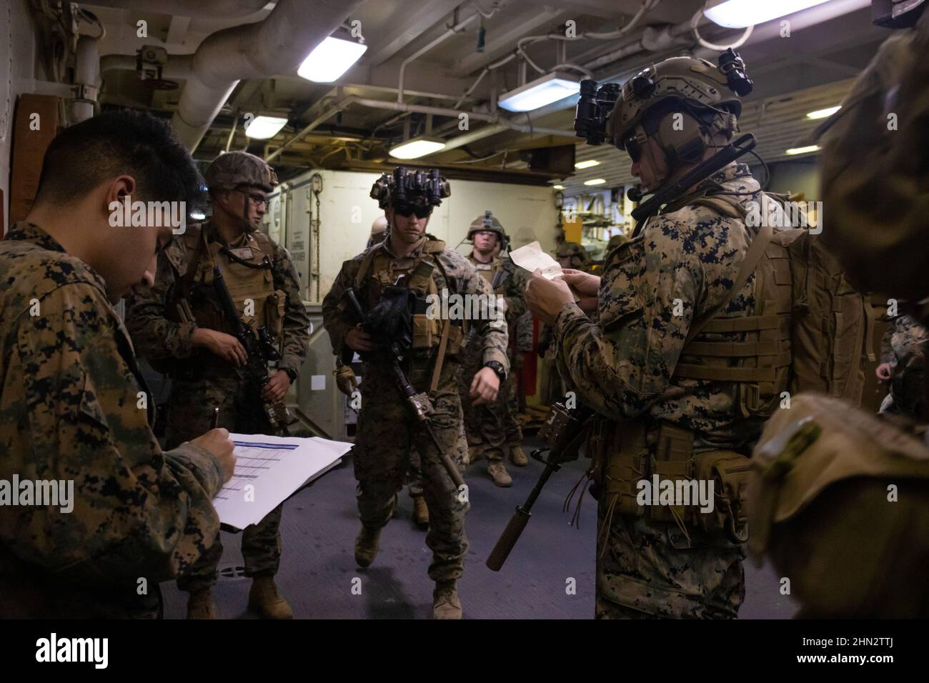 U.S. Marines mit Bataillon Landing Team 1/5, Marine Expeditionary Unit (MEU), beginnen ihr Team auf der Rampe zur Fluglinie an Bord des amphibischen Angriffsschiffs USS America (LHA 6) zu stationieren, bevor eine taktische Bergung von Flugzeugen und Personal (TRAP) durchgeführt wird, Philippine Sea, 9. Februar 2022. Neben der Rückgewinnung von Personal und Flugzeugen sind DIE TRAP-Teams auch damit beauftragt, sensibles Material zu zerstören, wenn es als notwendig erachtet wird, um dem Feind den Zugang zu verweigern. Die 31st MEU ist an Bord von Schiffen der America Expeditionary Strike Group im 7th Flottenbereich tätig, um die Interoperabilität zu verbessern Stockfoto