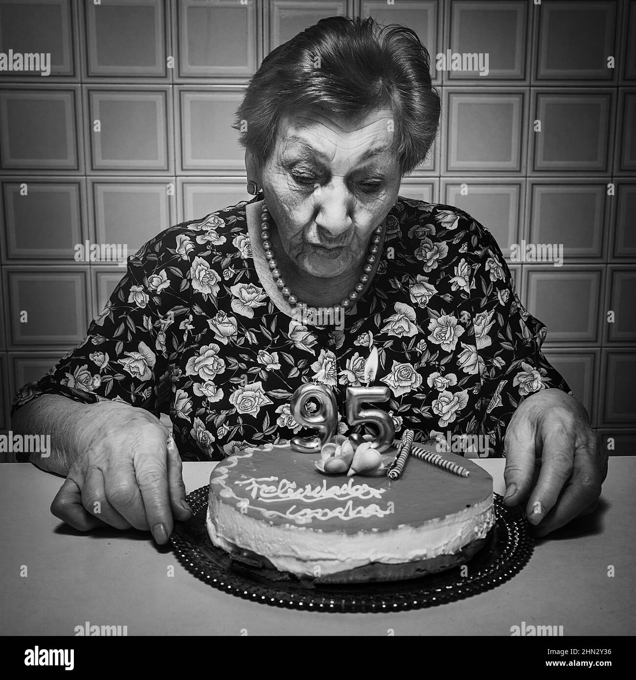 Alte Frau bläst Kerzen und feiert ihren 95th. Geburtstag in schwarz-weiß  Stockfotografie - Alamy