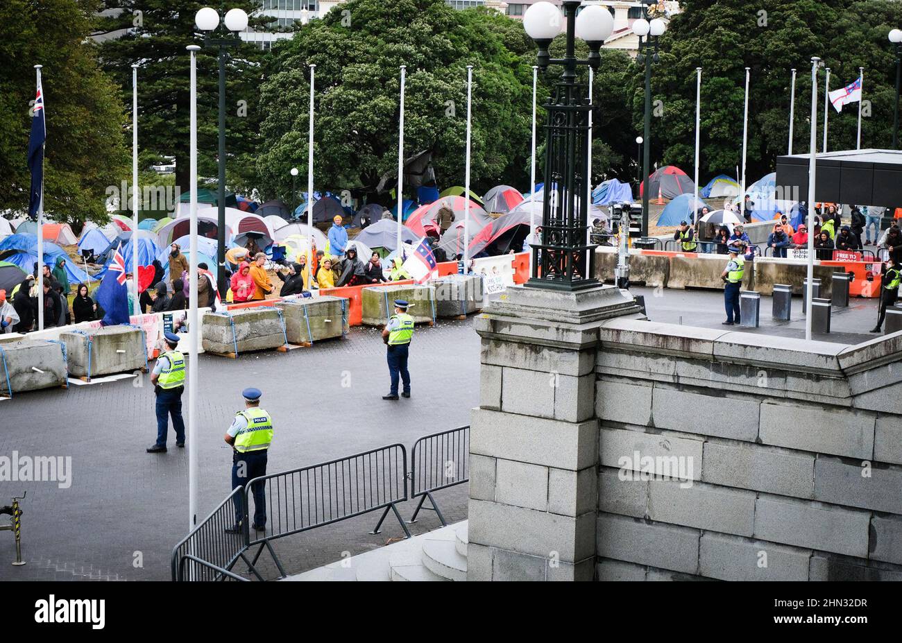 Wellington, Neuseeland. 14. Februar 2022: Polizeibeamte stehen Wache, als die Besetzung des Geländes des des Parlaments aus Protest gegen Covid-19-Impfstoffbevollmächtigungen und Beschränkungen für nicht geimpfte Personen, die Bars, Restaurants und bestimmte andere Orte betreten, in den siebten Tag eintritt. Quelle: Lynn Grieveson/Alamy Live News Stockfoto