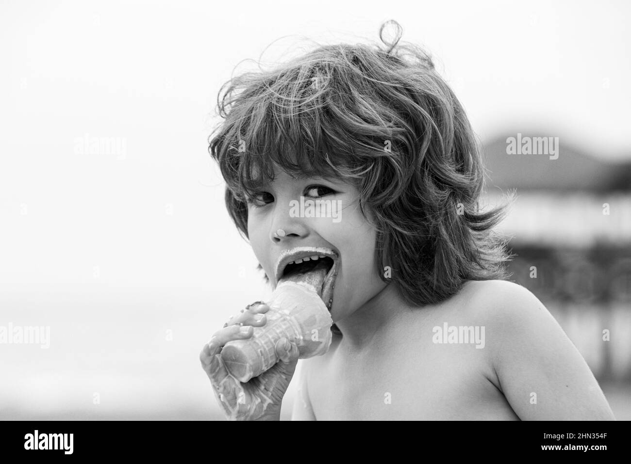 Kleines Kind, das Eis isst. Niedlicher Junge Kind essen ein Eis im Freien. Stockfoto