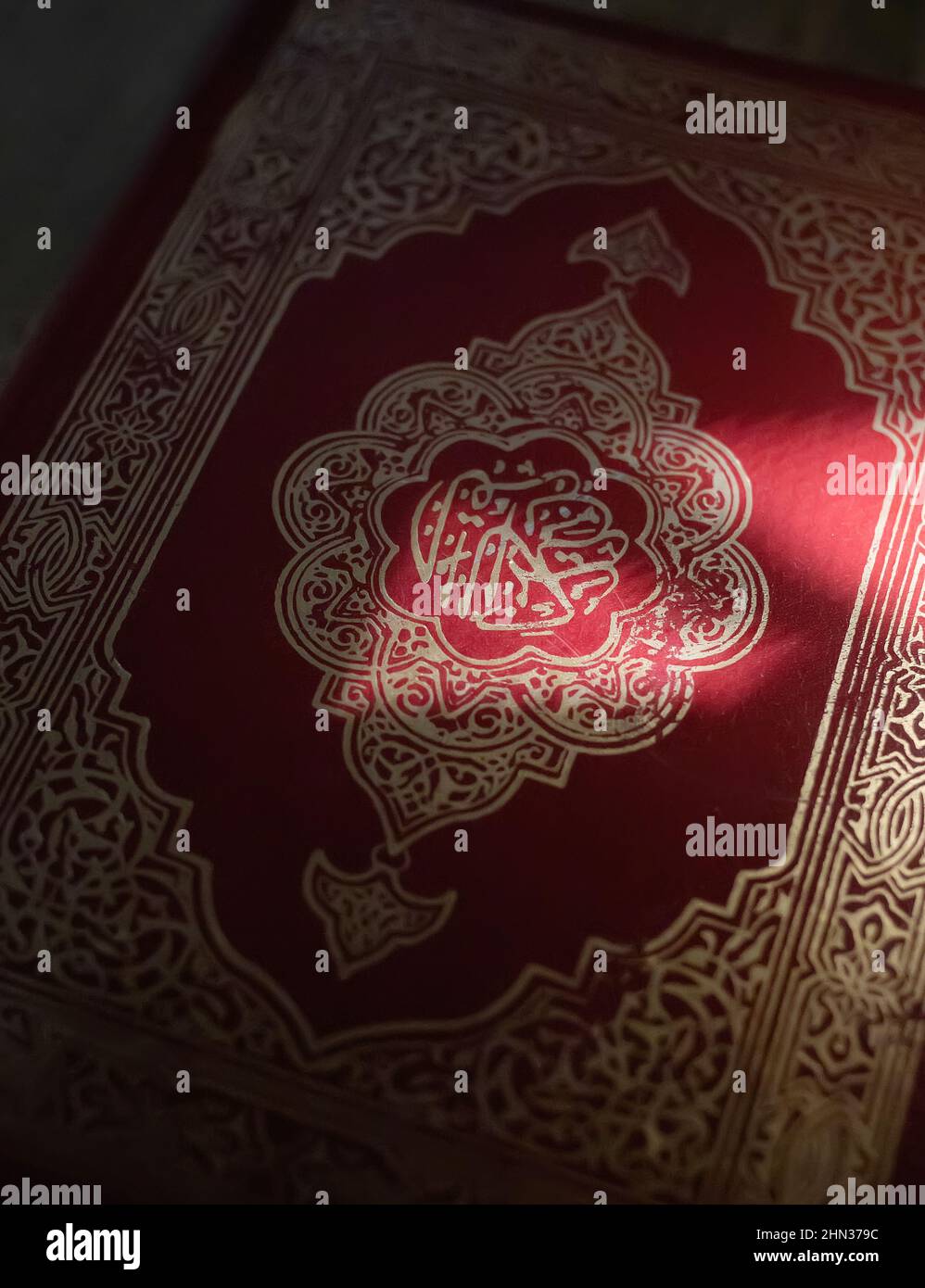 Sonnenlicht auf dem heiligen Koran muslimische arabische Buchcover aus nächster Nähe Stockfoto