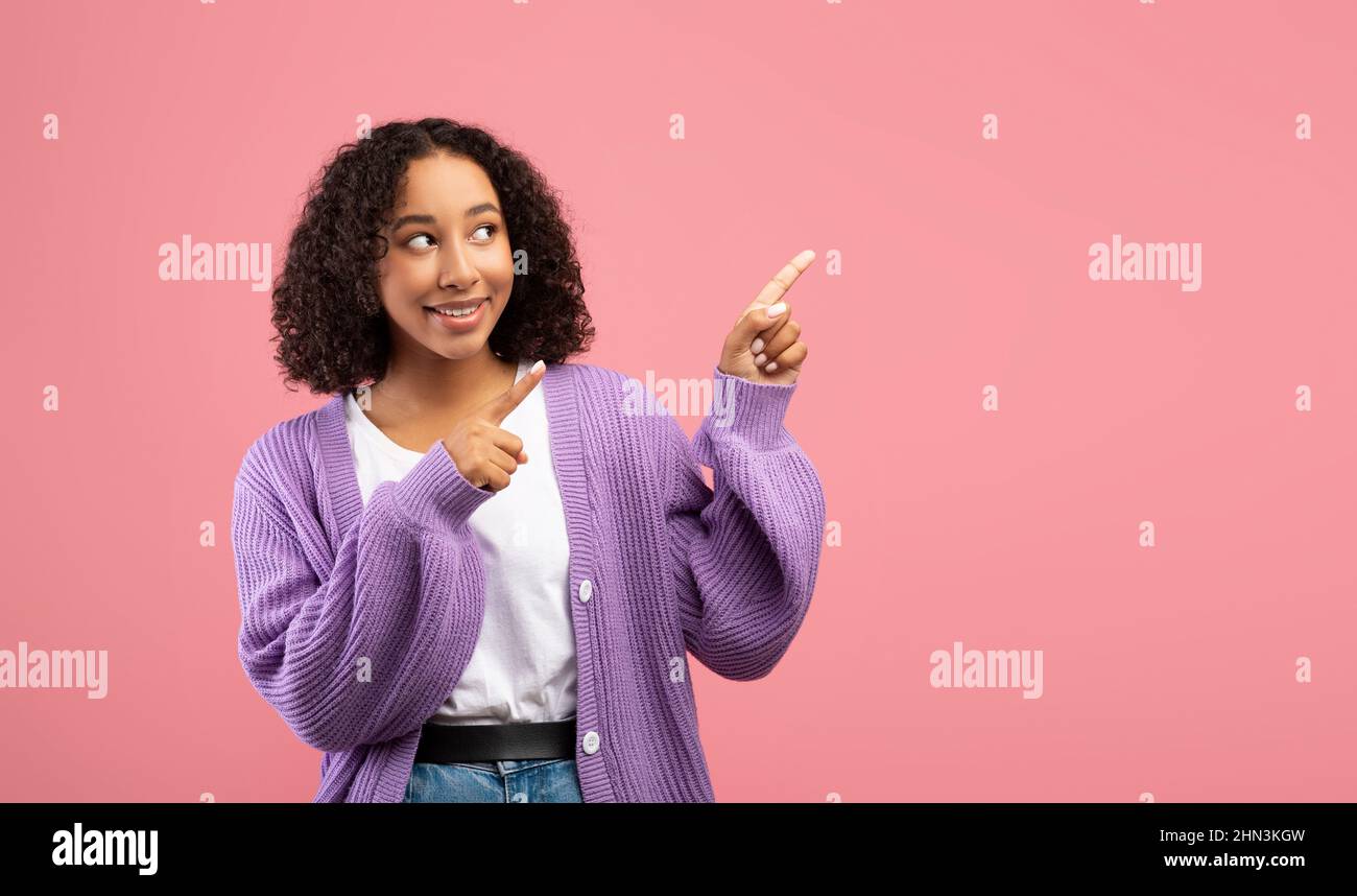 Tolle Promotion. Lächelnde junge schwarze Frau zeigt zur Seite und bietet leeren Raum für Ihr Werbedesign Stockfoto