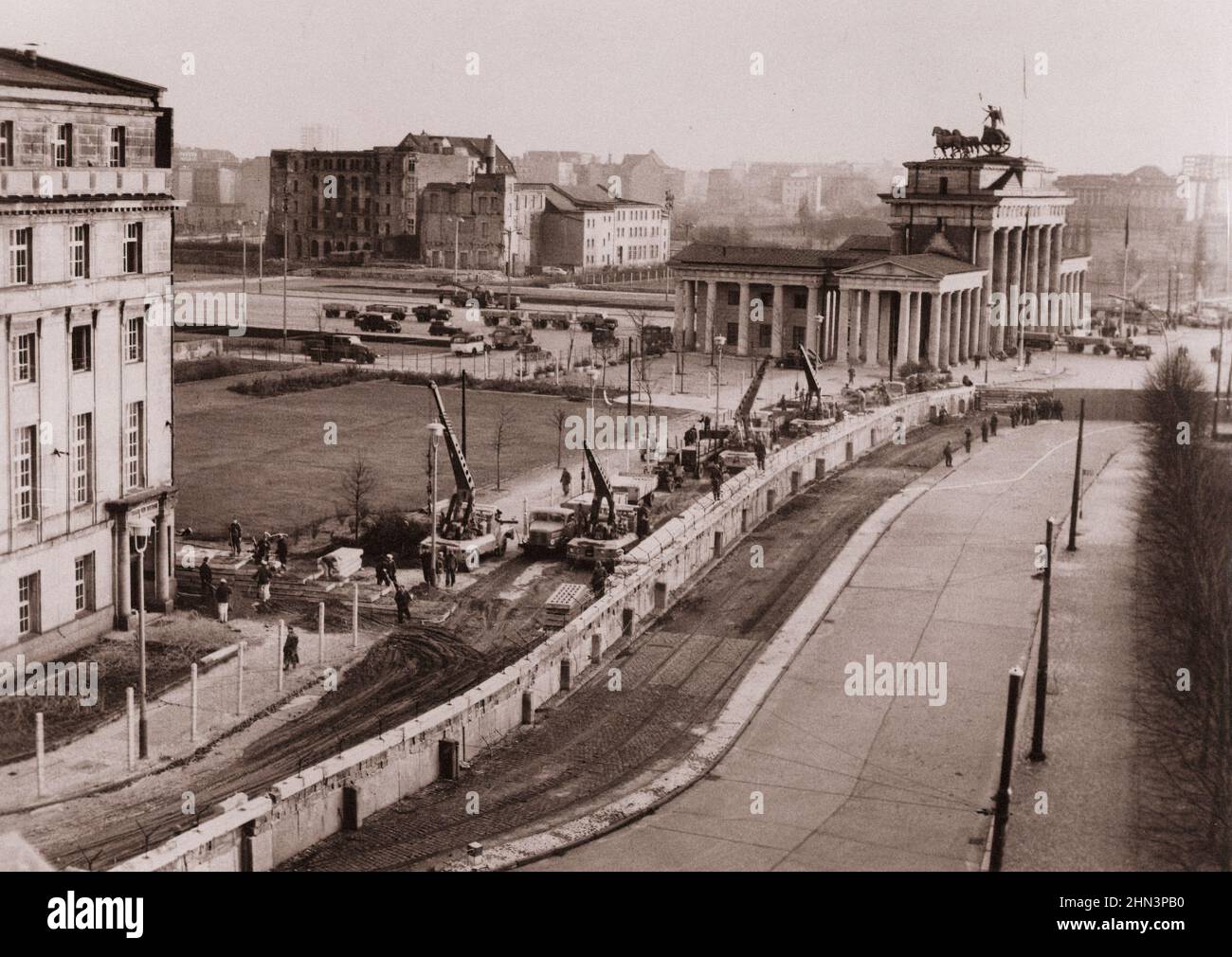 Vintage-Foto der Berliner Krise von 1961: Mauerbau Berliner Mauer verstärkt. Unter den wachsamen Augen der kommunistischen Polizei waren ostdeutsche Arbeiter in der Nähe Stockfoto