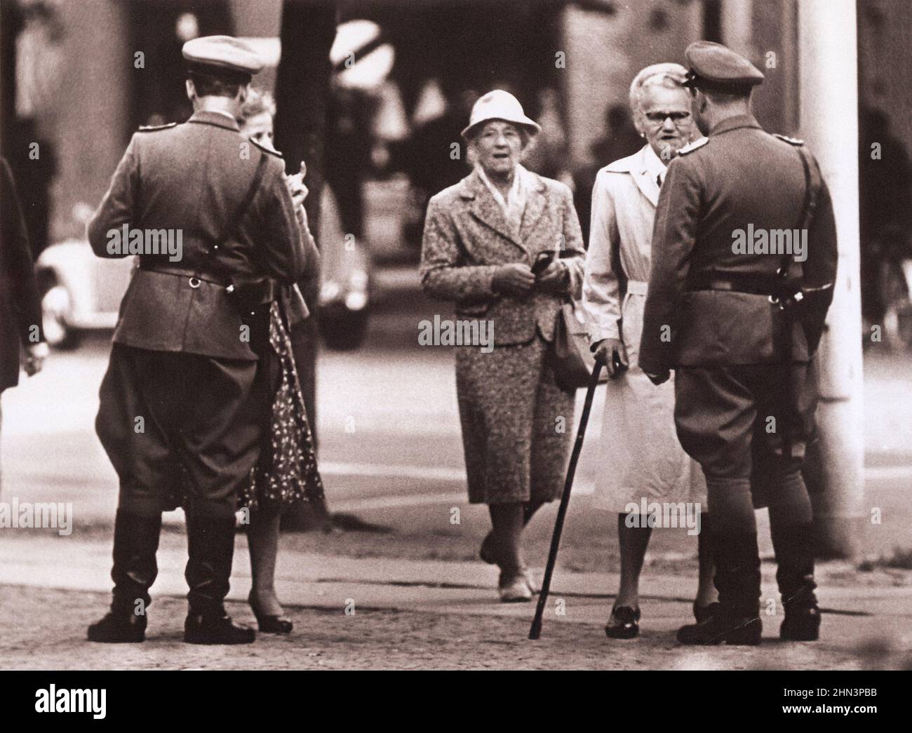Vintage-Foto der Berliner Krise von 1961: Mauerbau zwei 'Vopos' (DDR-Polizei) überprüfen Ost-Berliner, die am Brandenburger Tor vorbei wollen Stockfoto