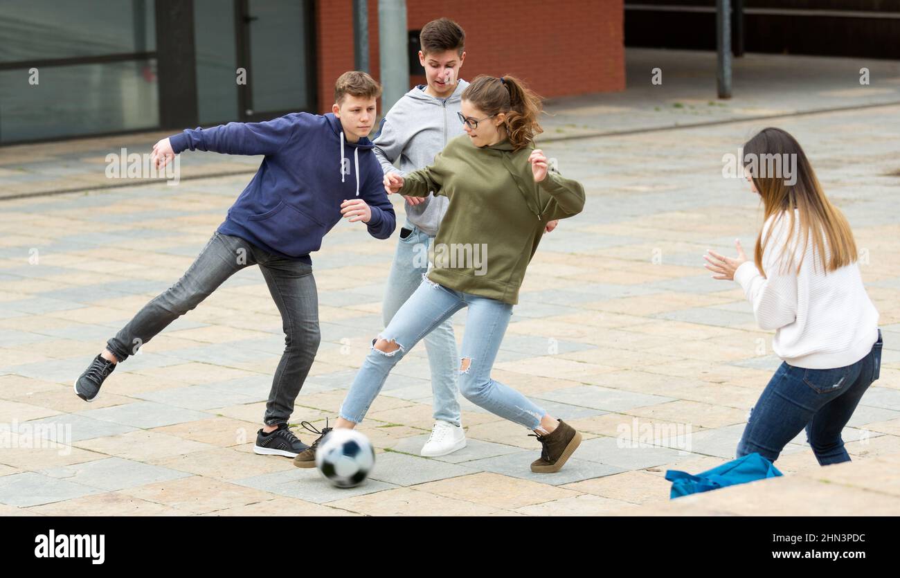 Fröhliche Schüler spielen Fußball Stockfoto