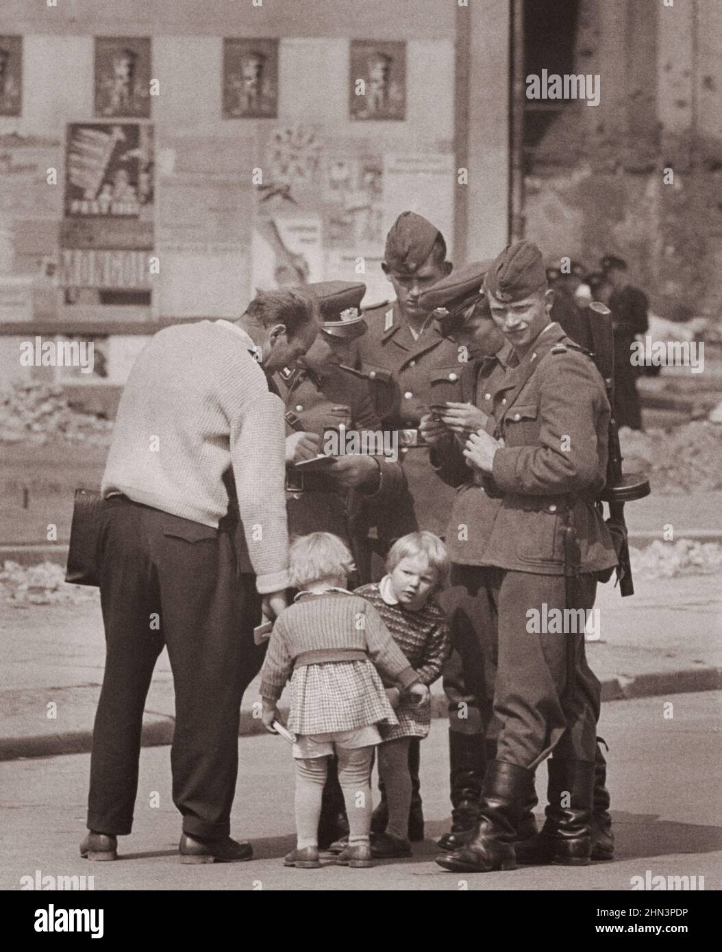 Vintage-Foto der Berliner Krise von 1961: Mauerbau. West Berliner (links), begleitet von seinen beiden Töchtern, sucht Informationen über seine Frau her Stockfoto