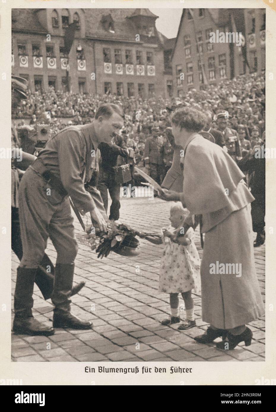 Alte deutsche Propagandapostkarte: Ein kleines Mädchen übergibt einen Blumenstrauß an Adolf Hitler. 1930s nur für historische Purpopes! Stockfoto