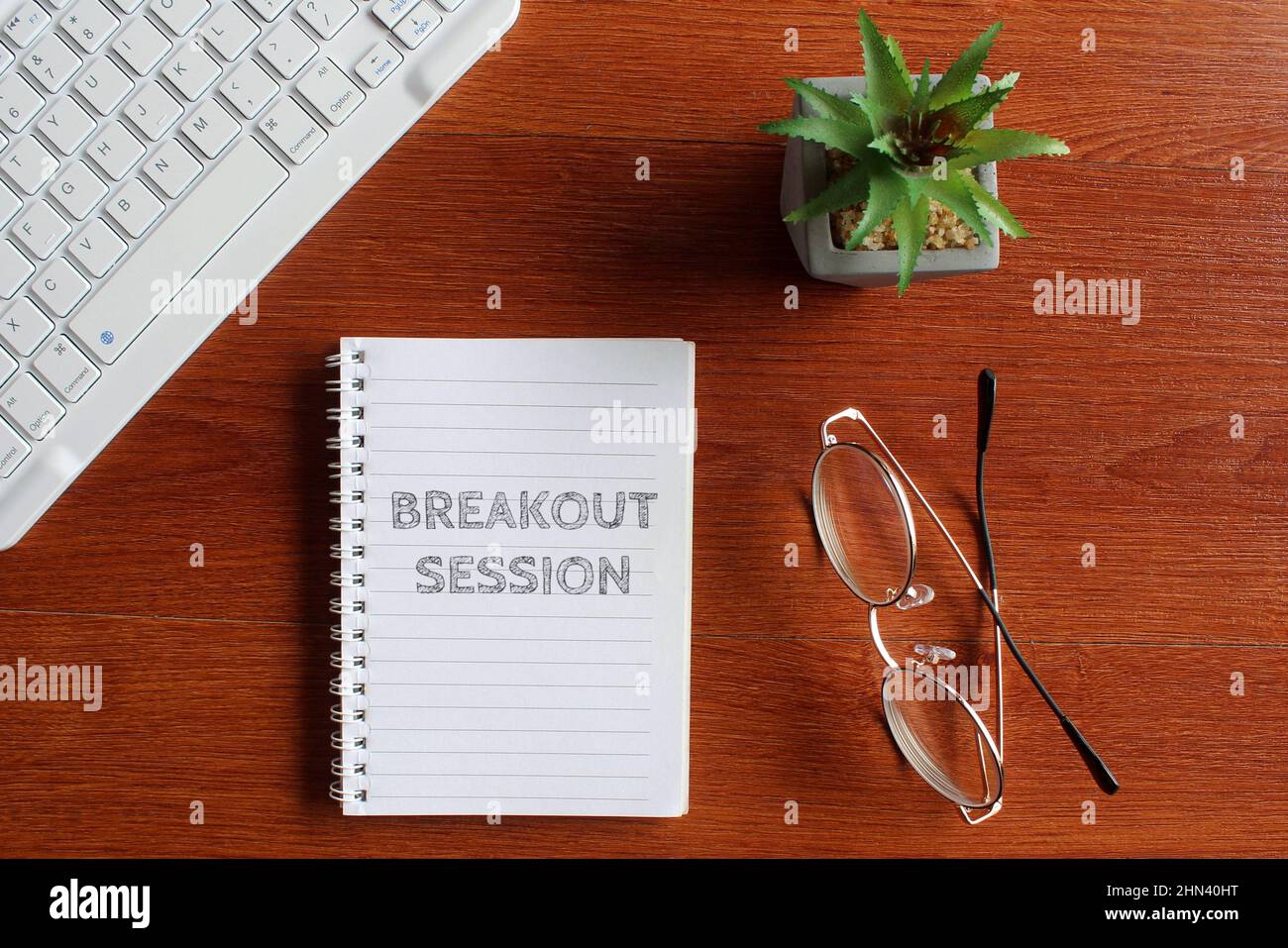 Draufsicht auf Tastatur, Brille und Notebook mit Text BREAKOUT-SESSION. Stockfoto
