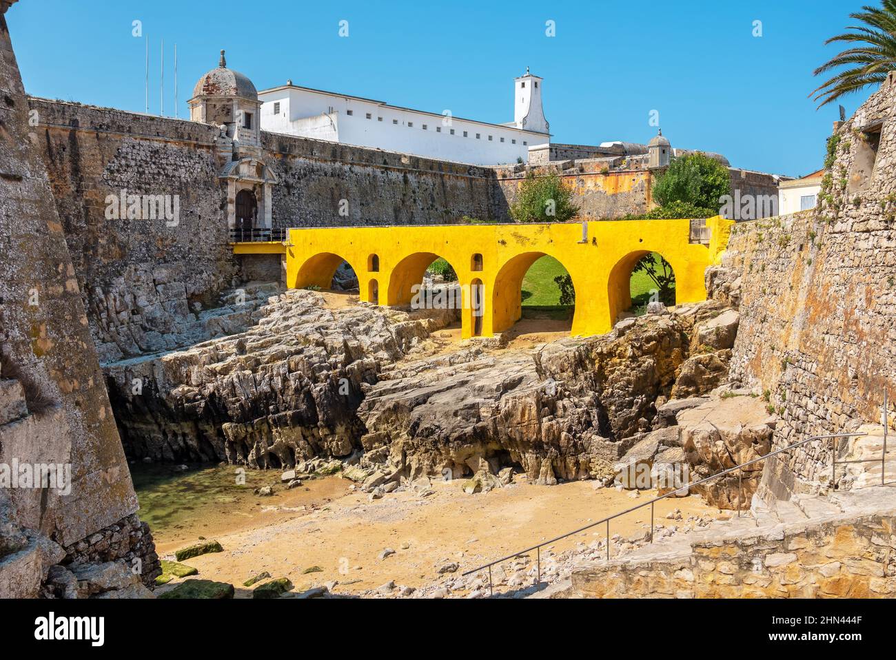 Blick von außen auf den Graben, die gelbe Brücke und die Festung von Peniche (Fortaleza de Peniche). Peniche, Bezirk Leiria, Portugal Stockfoto