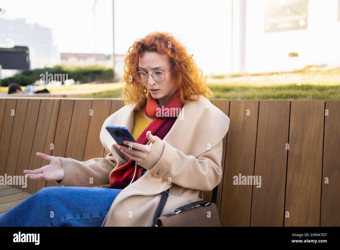 Eine Frau, die sich nach dem Lesen schlechter Nachrichten auf ihrem Smartphone in Bedrängnis äußert Stockfoto