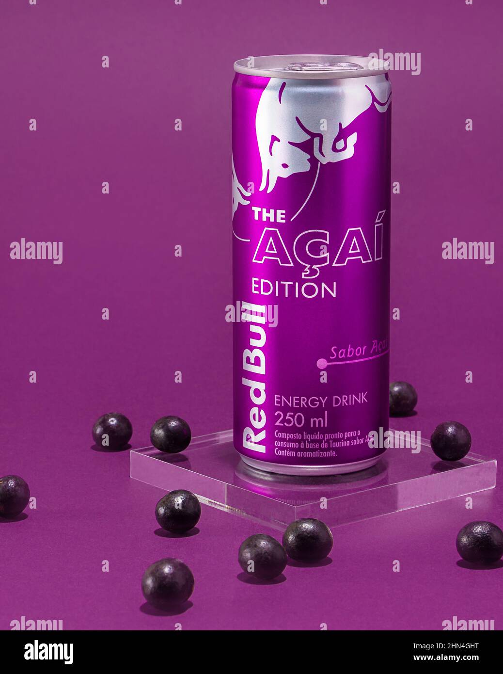 São Luís, Maranhão, Brasilien - 13. Februar 2022: Red Bull açaí Flavor Edition. açaí Beeren auf einem lila Hintergrund gespiegelt. Stockfoto