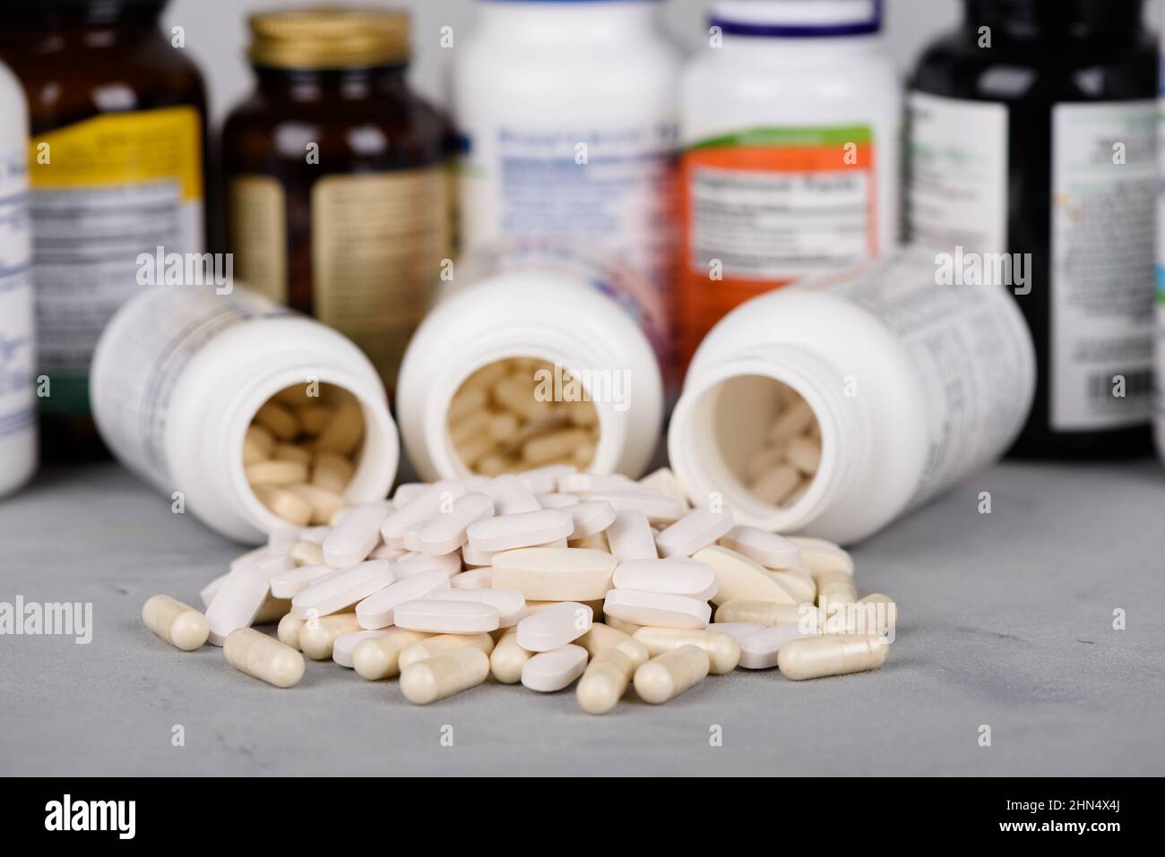Flaschen von Vitaminen und Nahrungsergänzungsmitteln mit Pillen auf dem Tisch Stockfoto