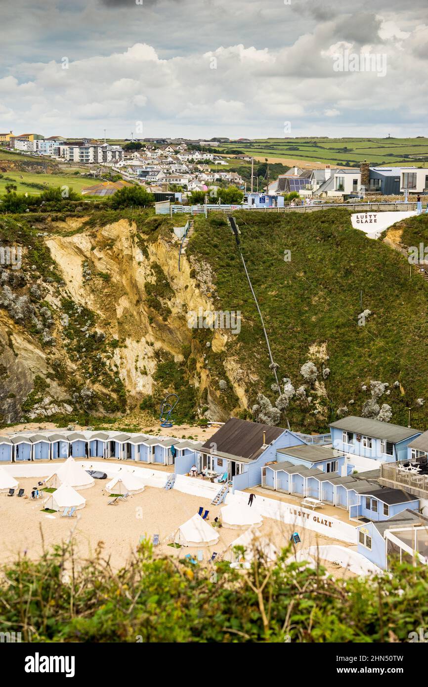 Blick auf die Lusty Glaze Bay, Cornwall, zeigt die Strandhütten vor dem Hintergrund der Klippen Stockfoto