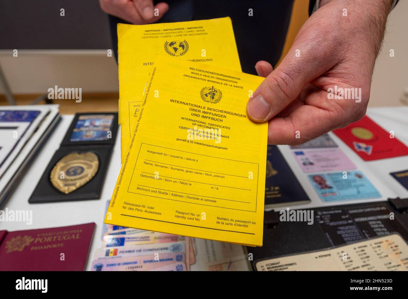 Passau, Deutschland. 14th. Februar 2022. Ein Polizeibeamter zeigt gefälschte Impfkarten am Rande der jährlichen Überprüfung der bayerischen Grenzpolizei 2021. Quelle: Armin Weigel/dpa/Alamy Live News Stockfoto