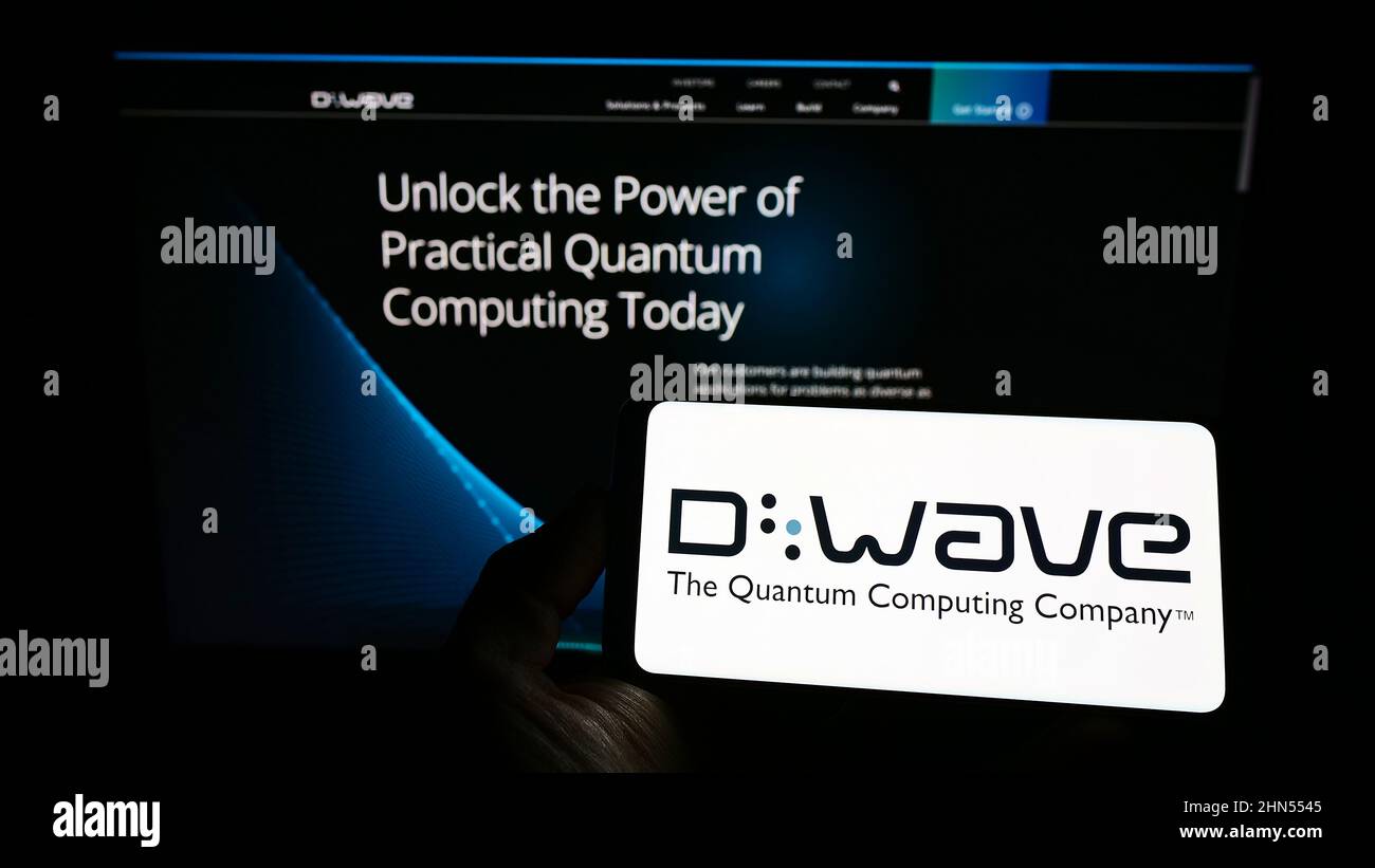 Person, die das Smartphone mit dem Logo des kanadischen Hardwareunternehmens D-Wave Systems Inc. Auf dem Bildschirm vor der Website hält. Konzentrieren Sie sich auf die Telefonanzeige. Stockfoto