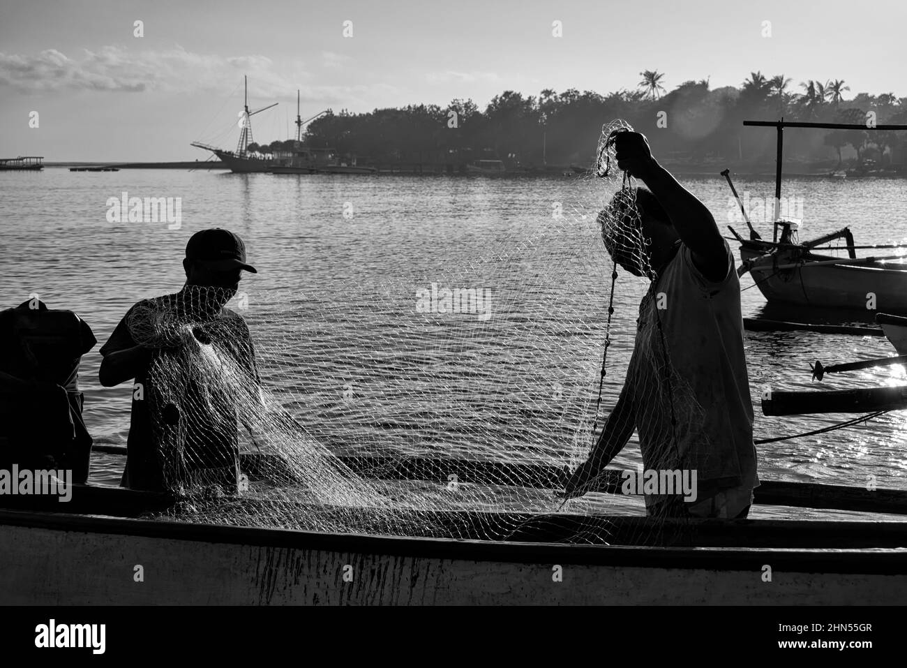 Silhouette von Fischern, die Fischernetz halten Stockfoto