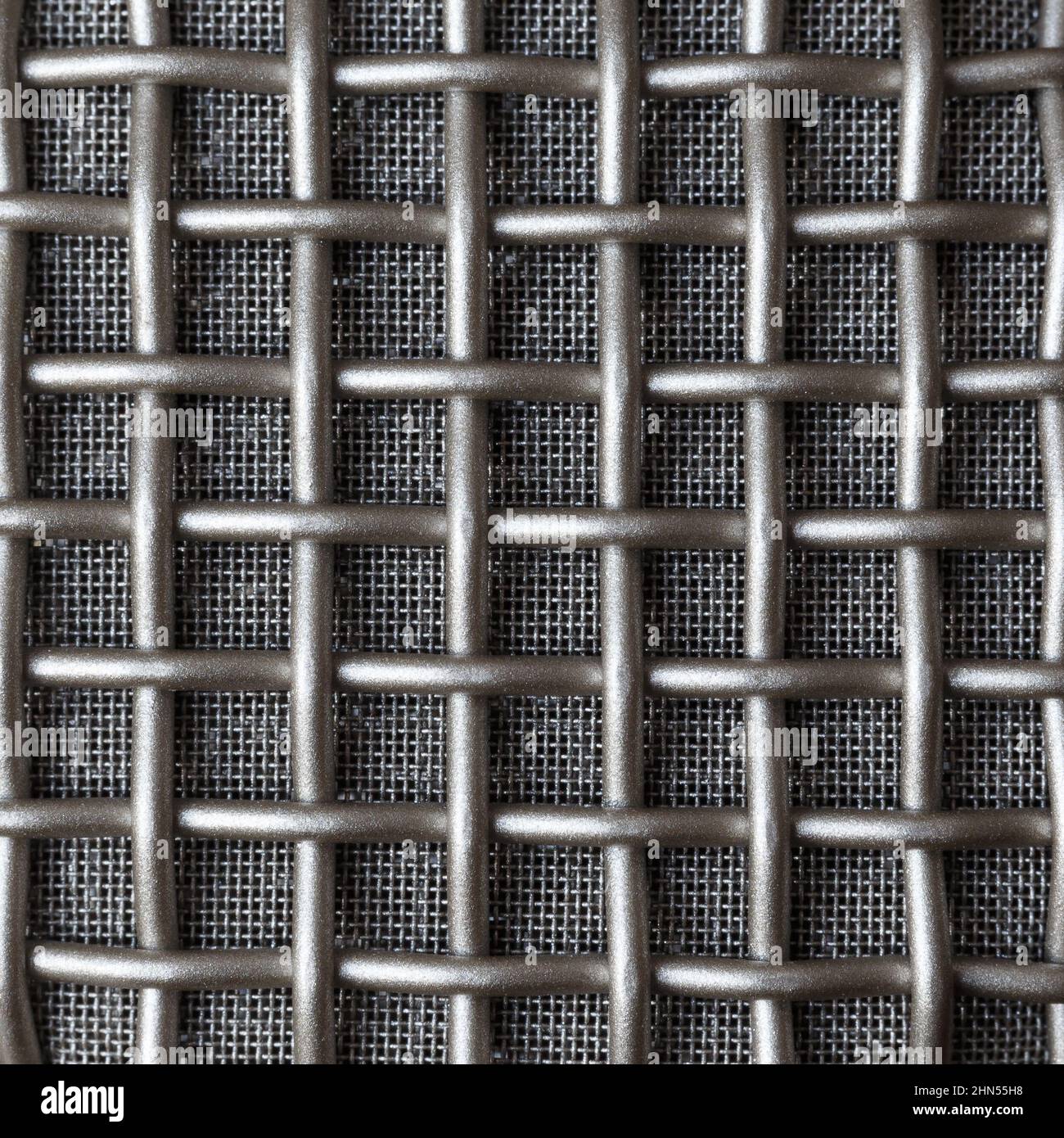 Doppeltes Metallgitter mit unterschiedlicher Dichte auf dem Mikrofon-Ohrpolster. Makro. Stockfoto