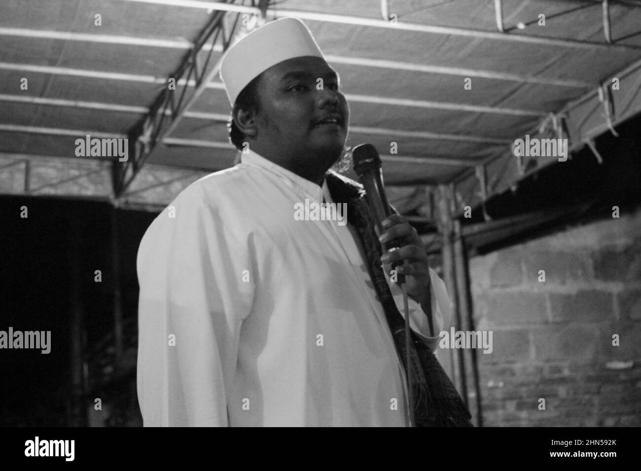 Jakarta, Indonesien - 11 19 2020: Ein Mann, der in islamischer Kleidung steht, spricht während der Feier des ISR des Propheten Muhammad durch ein Mikrofon Stockfoto