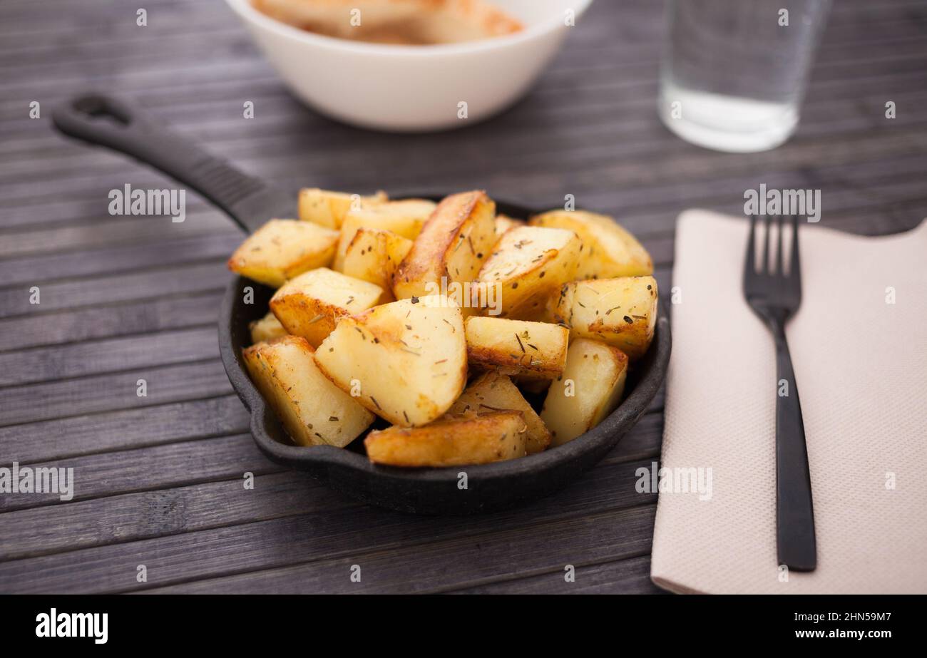 Scheiben gebratener Kartoffeln auf einer gusseisernen Snack-Pfanne Stockfoto