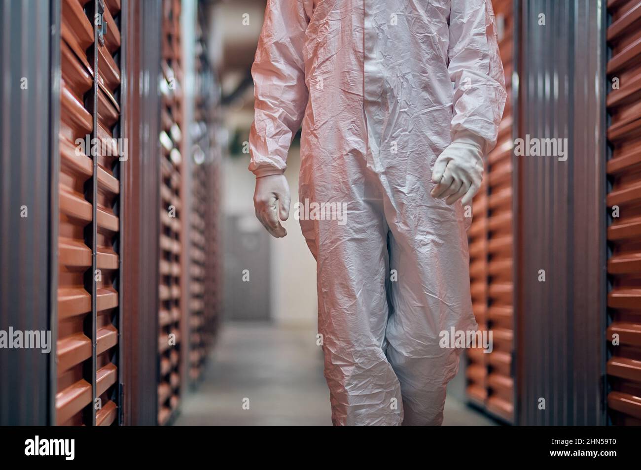 Arbeiter in einem Gefahrgutanzug, der die Lagerausrüstung inspiziert Stockfoto