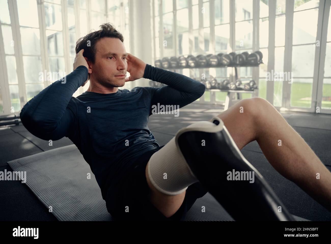 Mann mit prothetischen Bein Durchführung knirscht in einer Turnhalle. Paralympics-Athlet Stockfoto