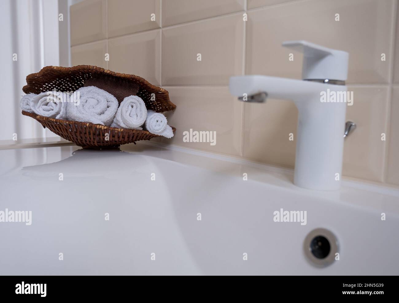 Weiße und braune Frottee-Handtücher in einem Korbkorb Stockfoto