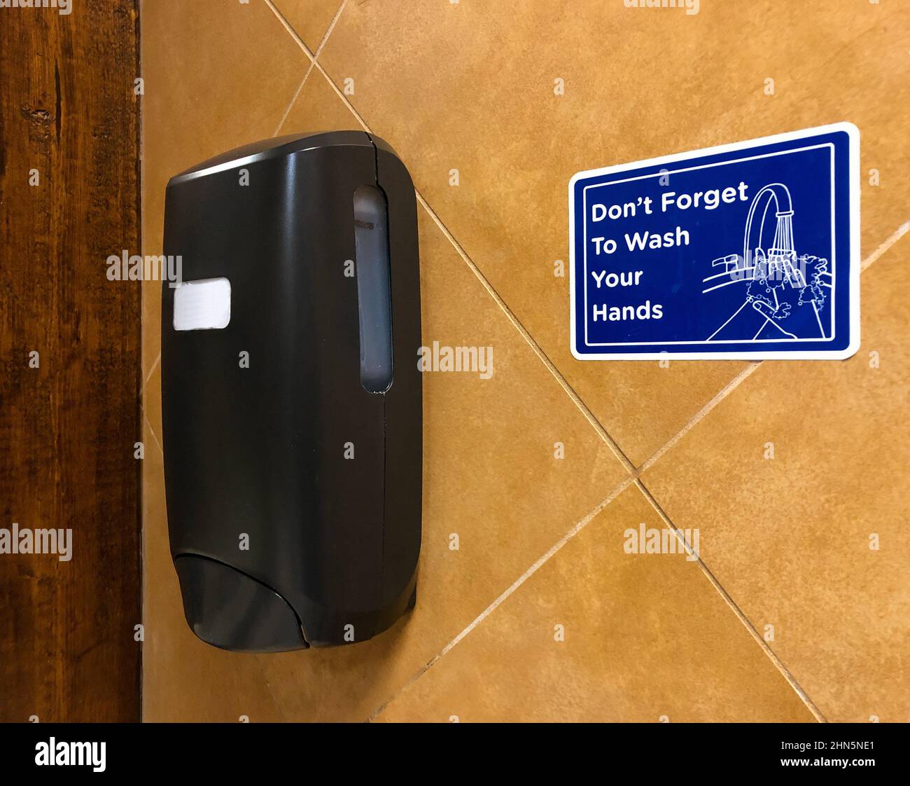 Blaues Schild mit Seifenspender, der die Menschen daran erinnert, sich die Hände zu waschen Stockfoto