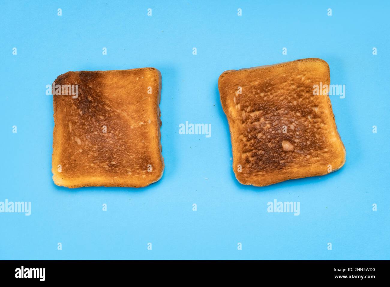 Zwei Toaststücke auf blauem Hintergrund. Lebensmittelkonzept. Stockfoto