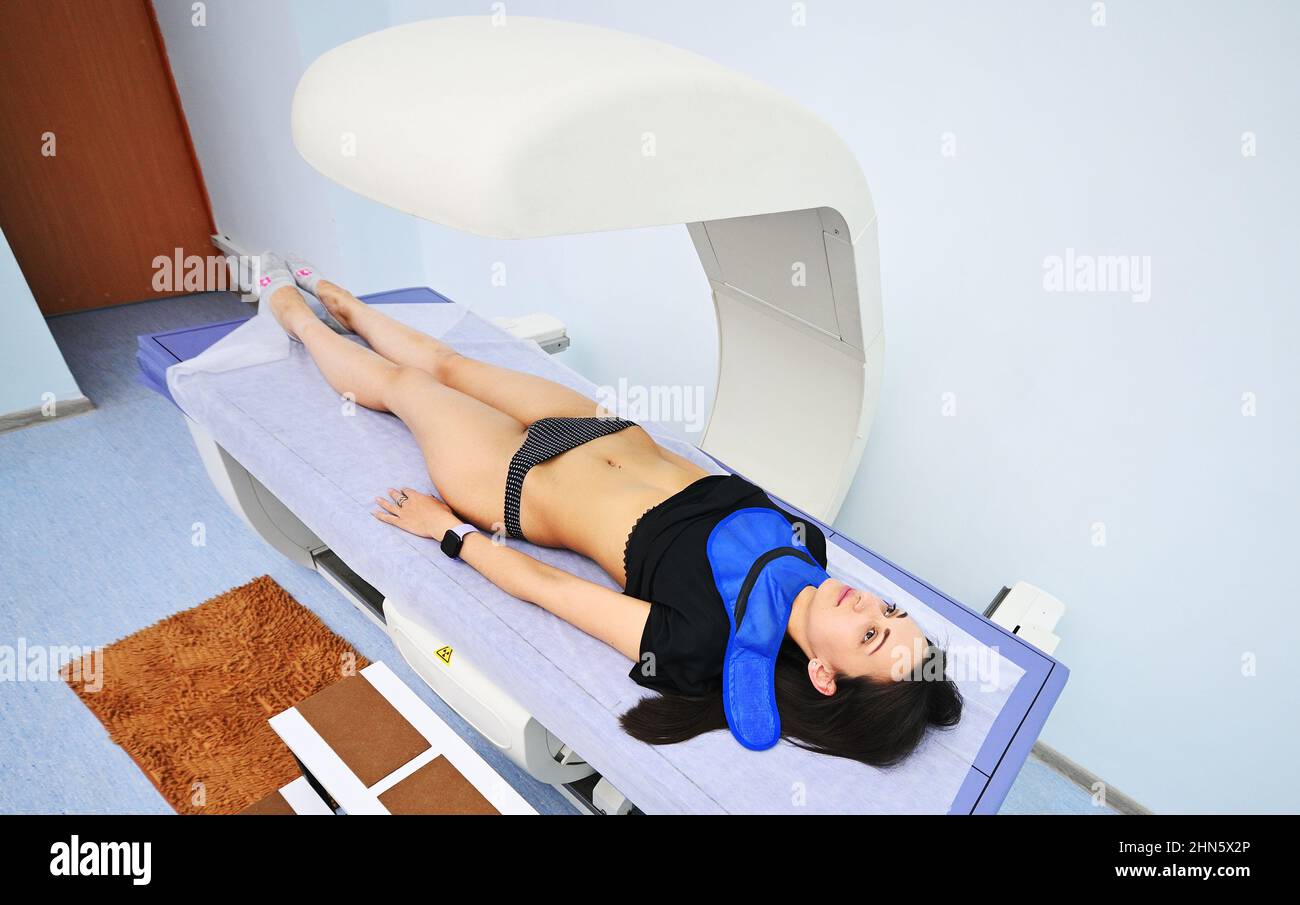 Junges hübsches Mädchen auf Untersuchung in einer modernen Klinik durch Densitometrie Stockfoto