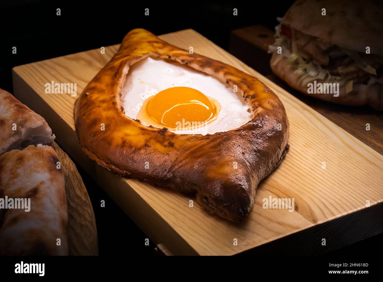 Traditionelle georgische Küche. Ajara khachapuri auf einem Holzbrett Stockfoto