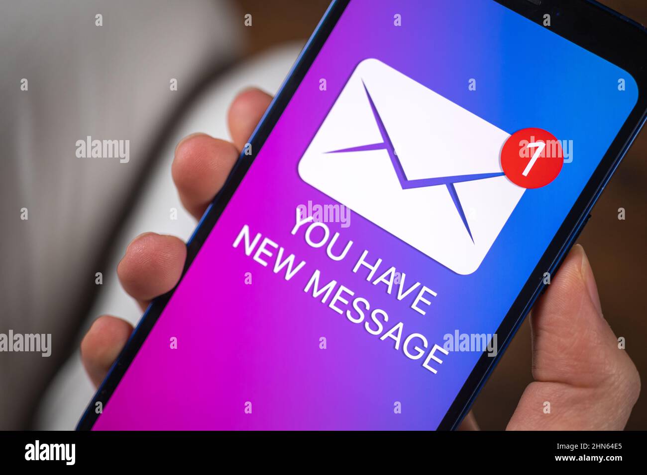 Handliches Smartphone mit neuem Nachrichtenkonzept auf dem Bildschirm. Neuer Geschäftshintergrund für E-Mail-Benachrichtigungen Stockfoto