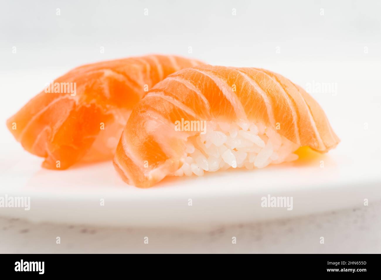 Lachs-Sushi auf dem Teller auf hellem Hintergrund Stockfoto