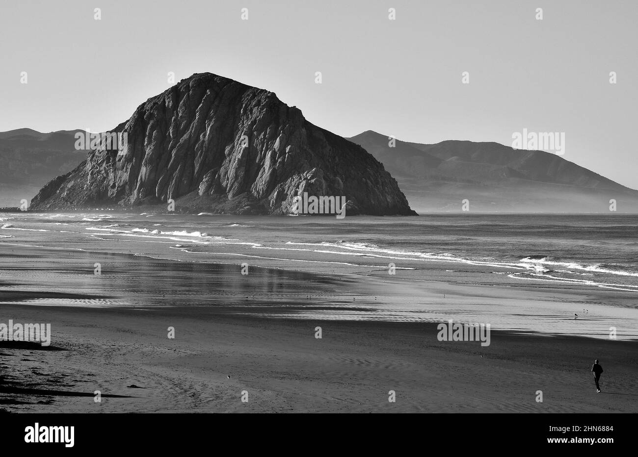 Schwarz-Weiß-Foto von Morro Rock and Beach in Morro Bay, Kalifornien an einem sonnigen Tag Stockfoto
