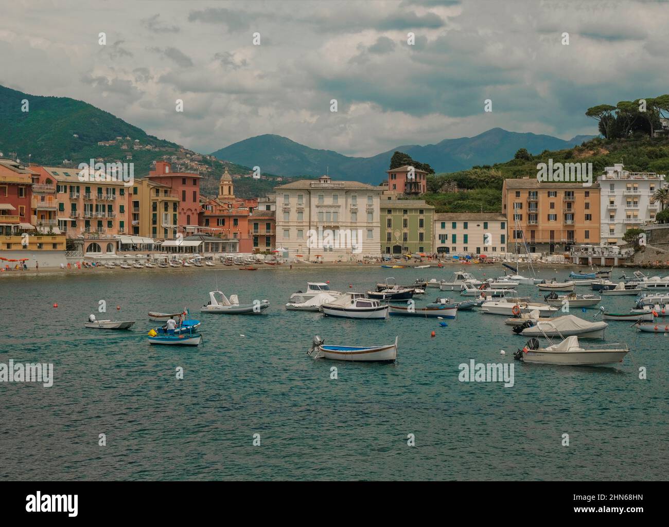 Boote in der Bucht von Silence, Baia di Silenzio in Sestre-Levante, Ligurien, Italien durch die bunten Gebäude, Berge und Himmel. Urlaubskonzept. S Stockfoto