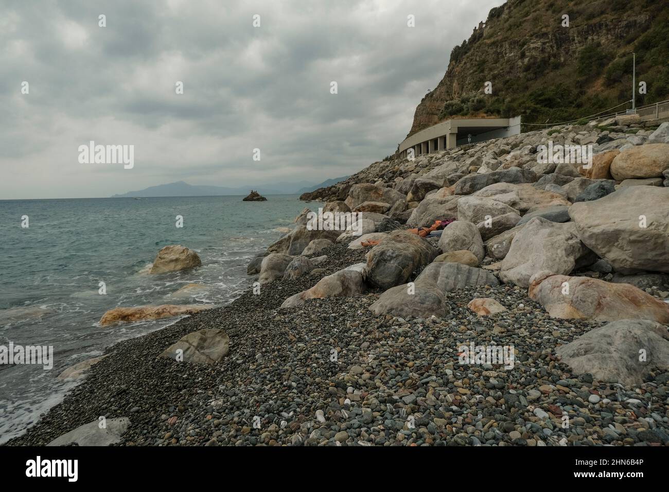 Felsige Küste des Meeres, Tunnel in den Bergen über den Meereshorizont, Berge und dramatischer Himmel. Landschaftlich reizvolle Landschaft. Sestri Levante, Italien, Ligurien Stockfoto