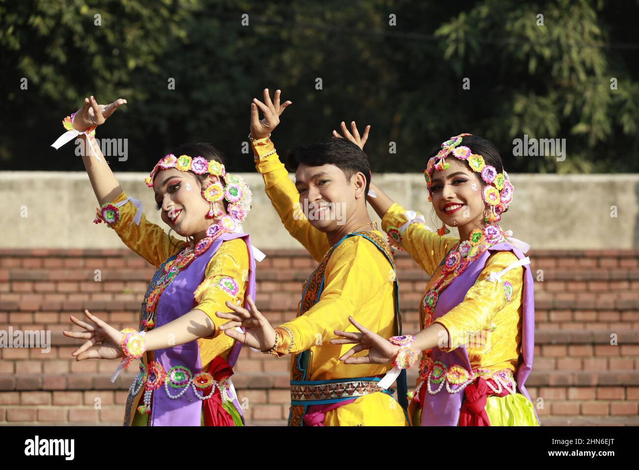 Dhaka, Bangladesch. 14th. Februar 2022. Künstler aus Bangladesch posieren für Fotos während der Feier des Pahela Falgun (Frühlingsfestes) in Dhaka, Bangladesch, am 14. Februar 2022. In Bangladesch ist Pahela Falgun mit bunten Feierlichkeiten gekennzeichnet und traditionell tragen Frauen gelbe Saris und Männer Panjabi, um diesen Tag zu feiern. Die Feier von Pahela Falgun ist als Bosonto Utsob bekannt. (Foto von Suvra Kanti das/Sipa USA) Quelle: SIPA USA/Alamy Live News Stockfoto