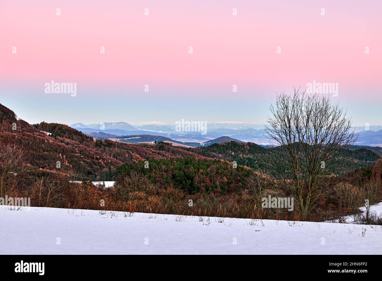 Am frühen Abend Winter Berglandschaft Blick auf das Tal mit Mischwald und Hügeln.Bunte Himmel. Natürlicher Hintergrund, Tapete. Vrsatec, Slowakei Stockfoto