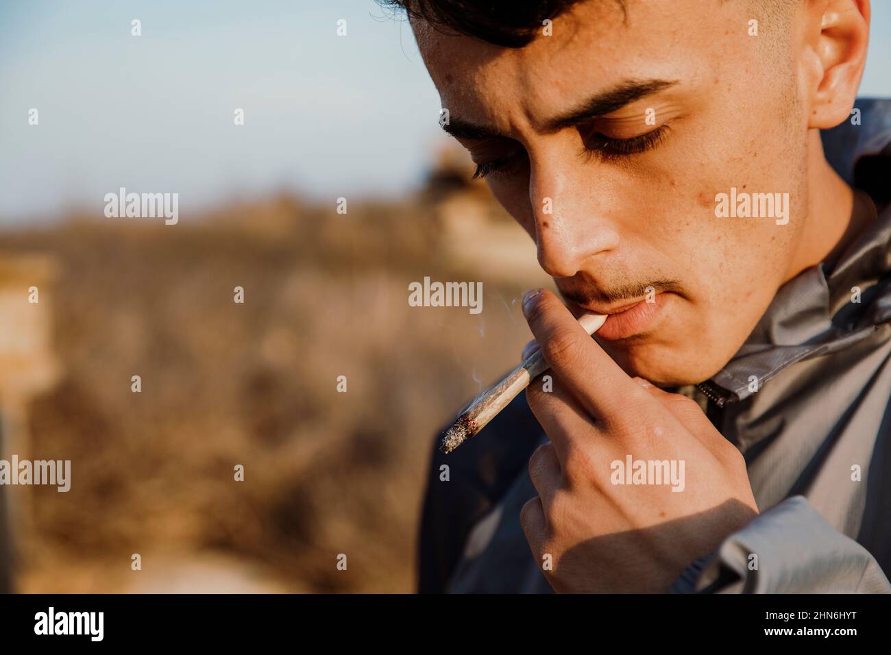 Nahaufnahme eines jungen Mannes, der im Freien ein Marihuanagelenk raucht Stockfoto