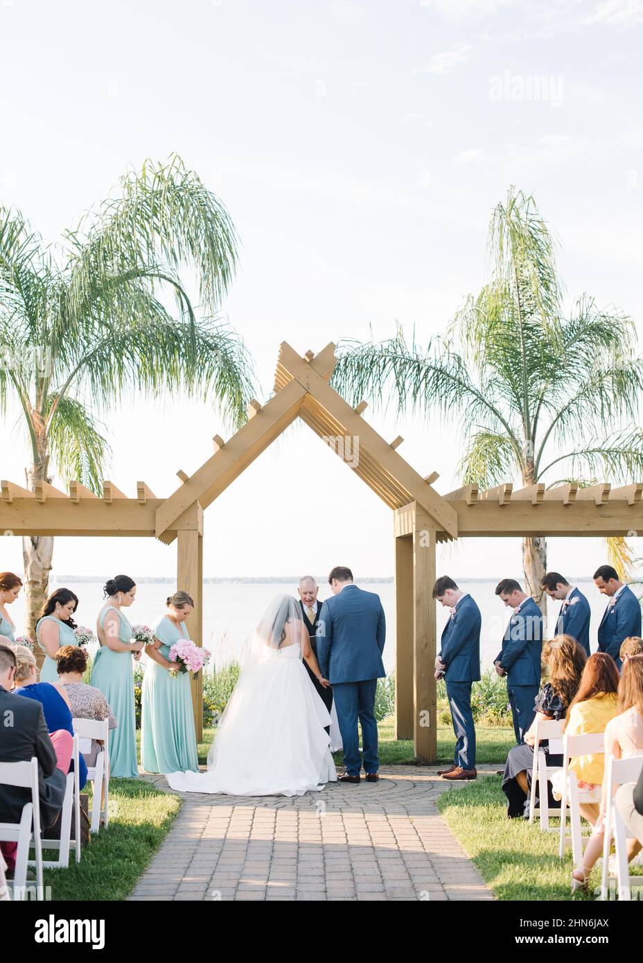 Die Köpfe der Braut und des Bräutigams verbeugten sich während der Hochzeitszeremonie am Wasser Stockfoto