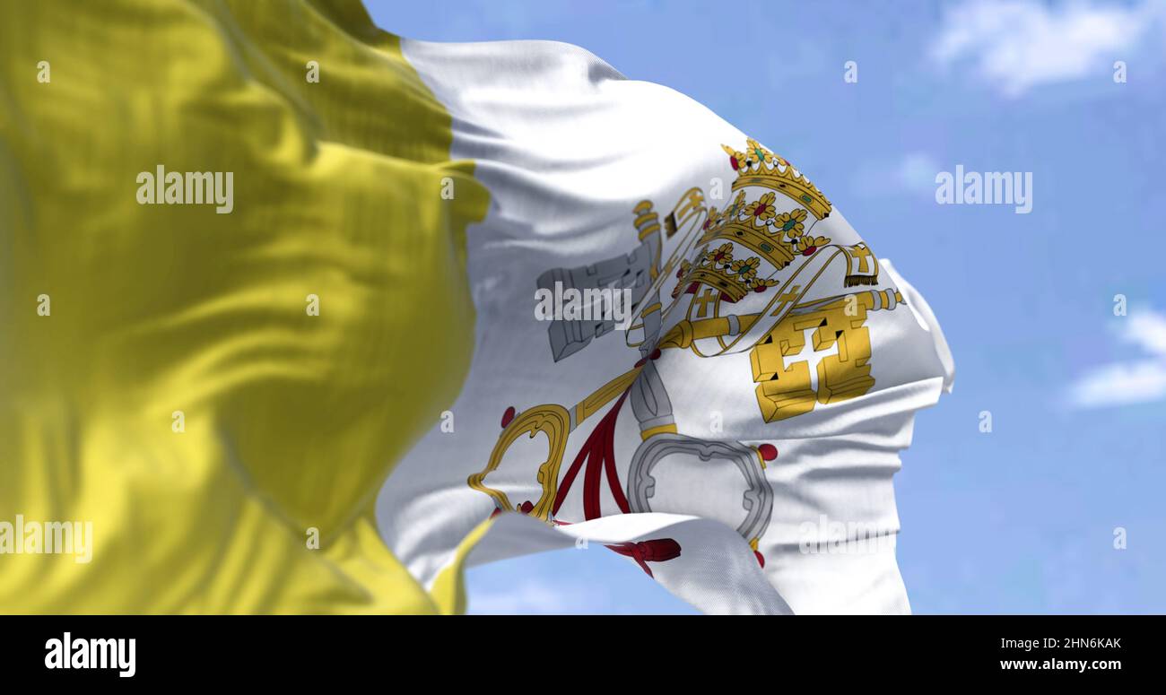 Detail der Nationalflagge des Vatikans, die an einem klaren Tag im Wind winkt. Religion und Politik. Selektiver Fokus. Stadtstaat in Rom, Italien Stockfoto