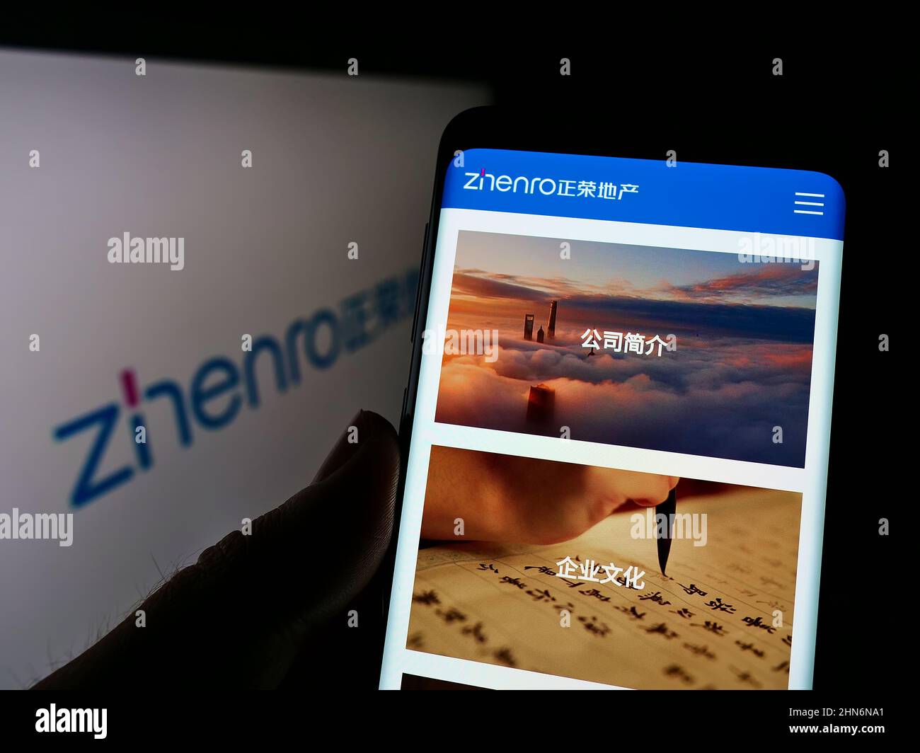 Person, die Smartphone mit Website der chinesischen Firma Zhenro Properties Group Limited auf dem Bildschirm mit Logo hält. Konzentrieren Sie sich auf die Mitte des Telefondisplays. Stockfoto