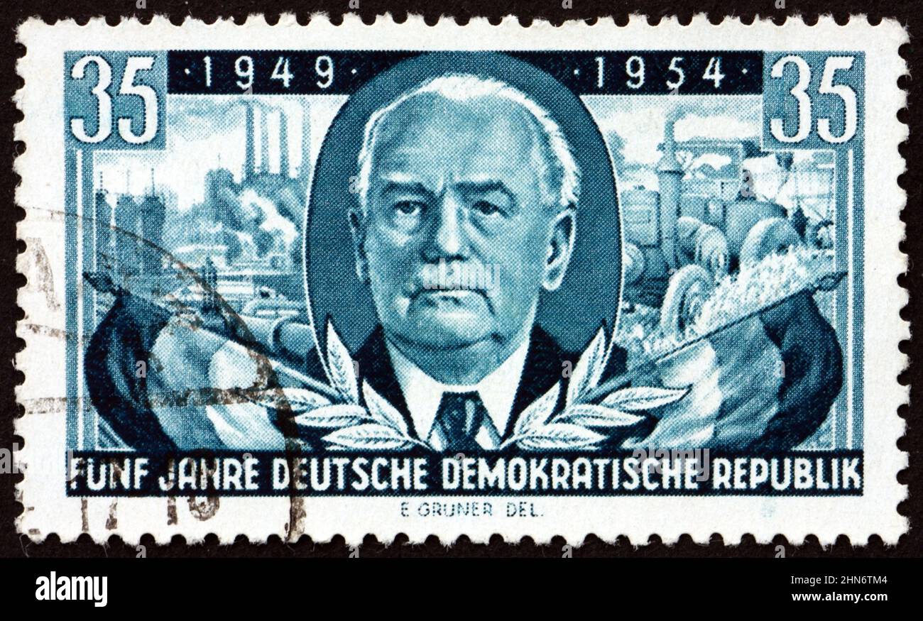 DEUTSCHLAND - UM 1954: Eine in Deutschland gedruckte Briefmarke zeigt Präsident Wilhelm Pieck und Flaggen, um 1954 Stockfoto