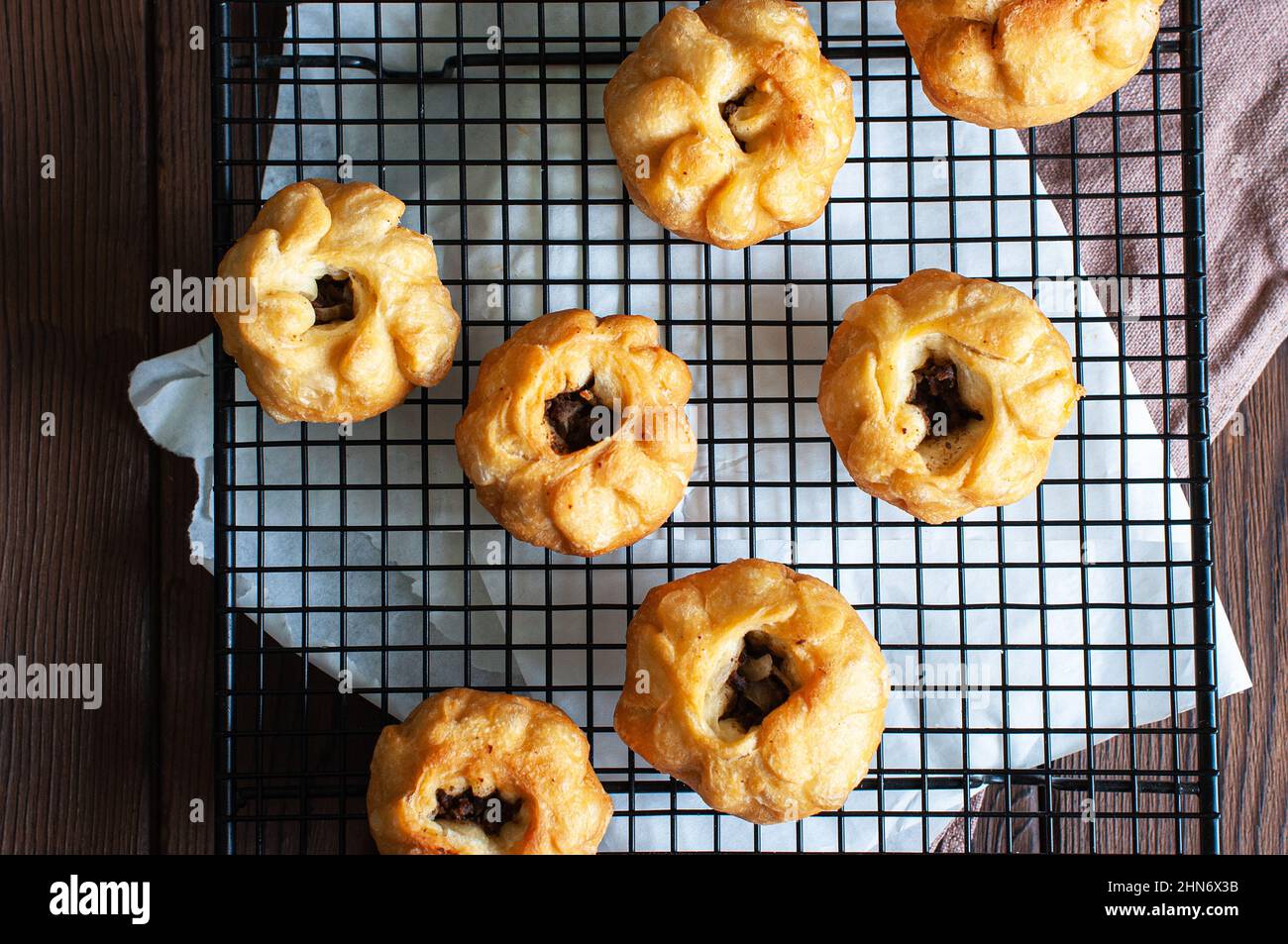 Gebratene Fleisch-Handgebäck - Belyash oder samsa auf einem Kühlregal. Draufsicht. Beliebte Nahost-Snacks oder Appetithappen. Stockfoto