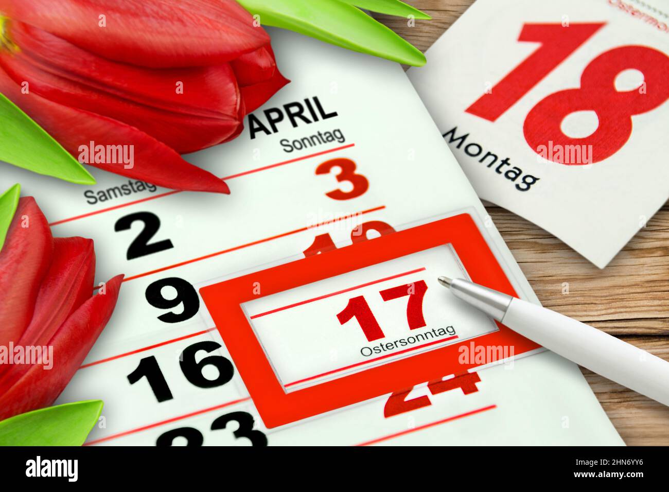 Deutscher Kalender Ostersonntag und Montag 2022. April 17 mit roten Tulpen auf Holzhintergrund Stockfoto