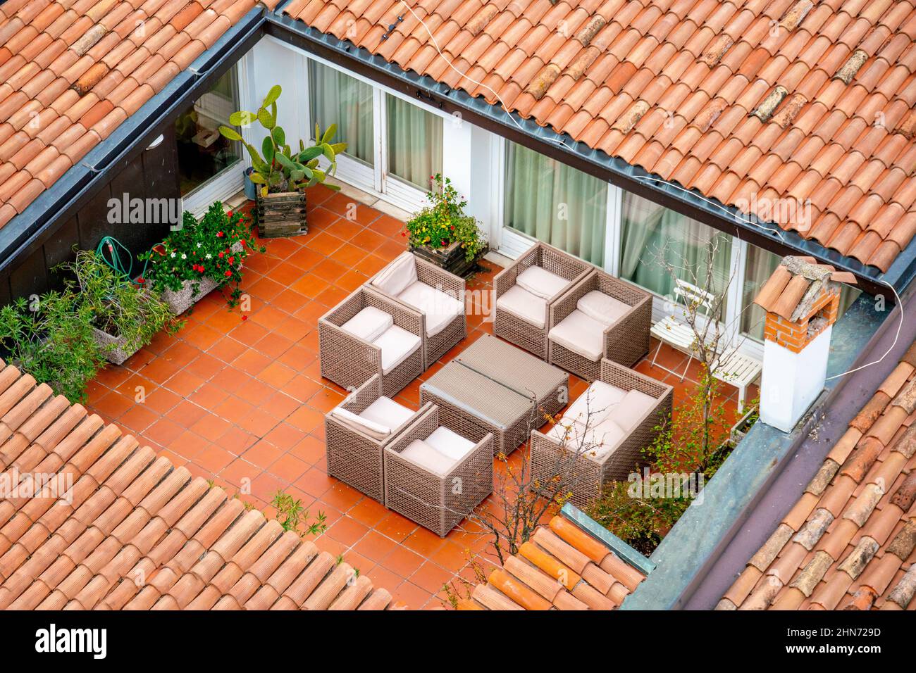 Draufsicht auf eine schöne Veranda des Hauses, Tisch, Stühle, Vegetation. Ein Ort zum Essen im Freien. Stockfoto